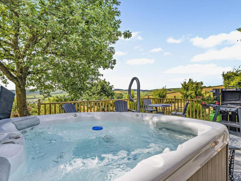 Beguildyにある1 Bed in Knighton 51898の木のあるデッキのホットタブ