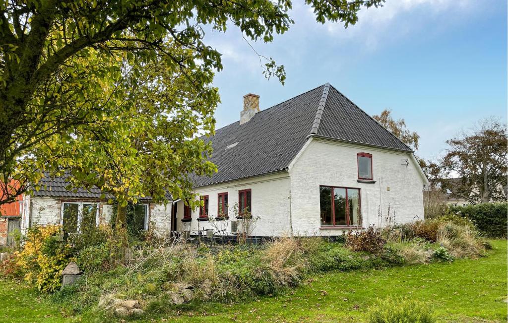an old white house with a black roof at 3 Bedroom Gorgeous Home In Søby Ærø in Soby Mark