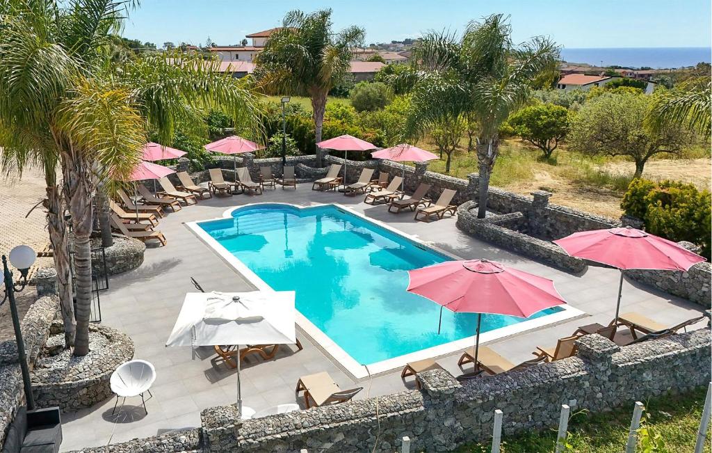 eine Draufsicht auf einen Swimmingpool mit Sonnenschirmen in der Unterkunft 1 Bedroom Cozy Apartment In Ricadi in San Nicolò