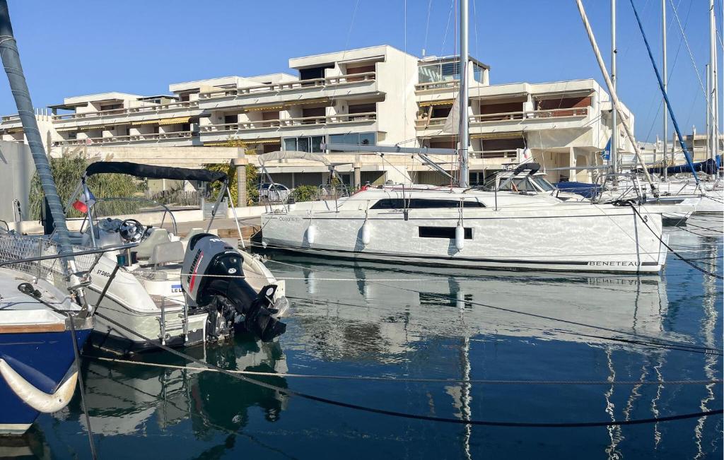 a white boat docked in a marina with a building at Beautiful Apartment In Le Grau-Du-Roi With Wifi in Le Grau-du-Roi