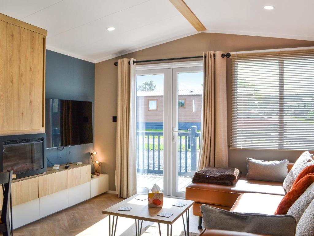 a living room with a couch and a tv at Solo's in East Heslerton