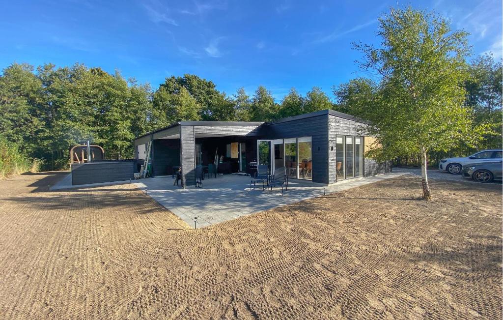 a small house in a field with a tree at Amazing Home In Glesborg With Sauna in Fjellerup Strand