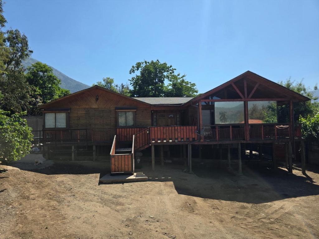 a log cabin with a porch and a house at Casa Divya in San José de Maipo