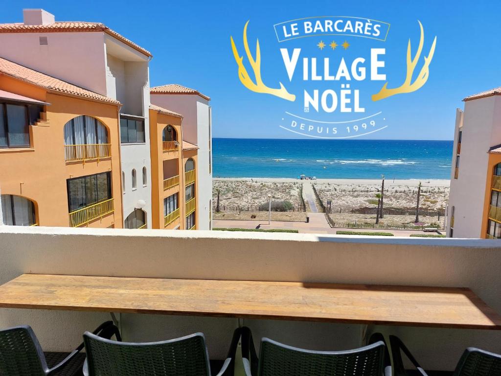 Una mesa en un balcón con vista a la playa. en Superbe vue mer avec accès direct plage et parking, en Le Barcarès