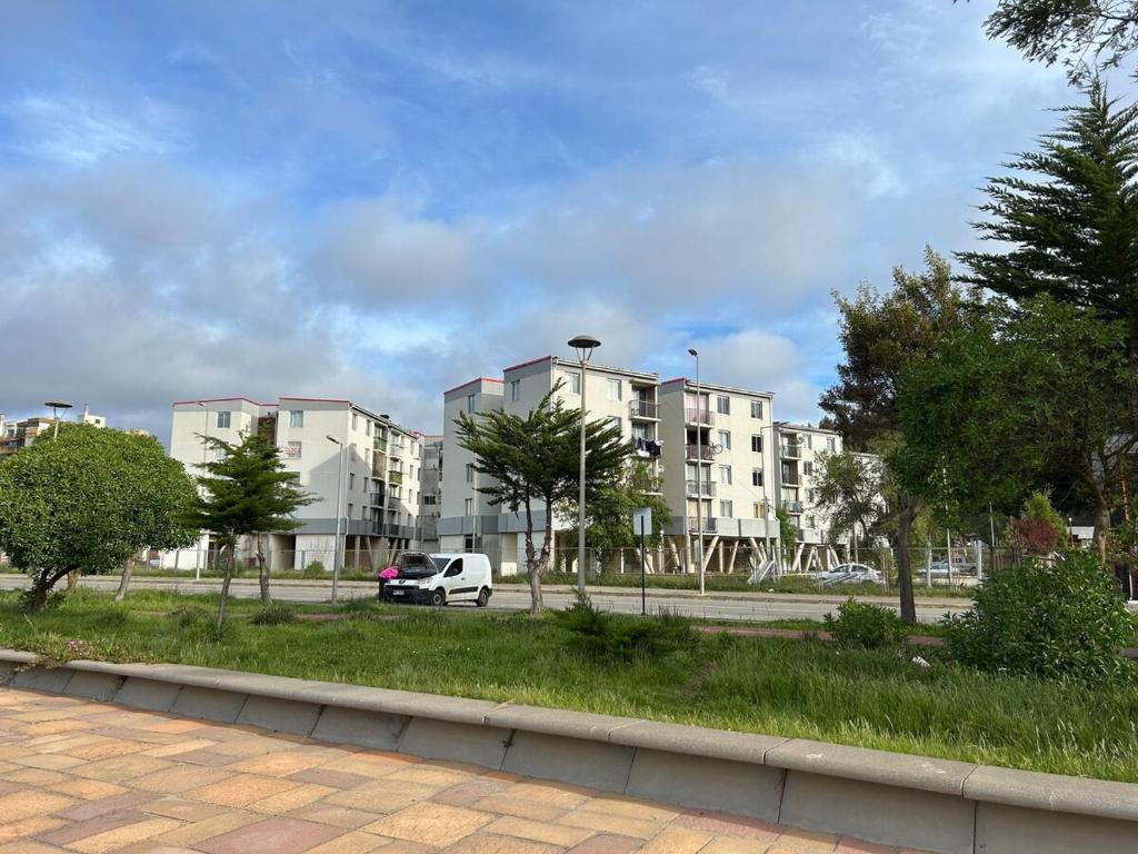 a white van parked in front of some buildings at Lindo y cómodo departamento en Dichato in Dichato