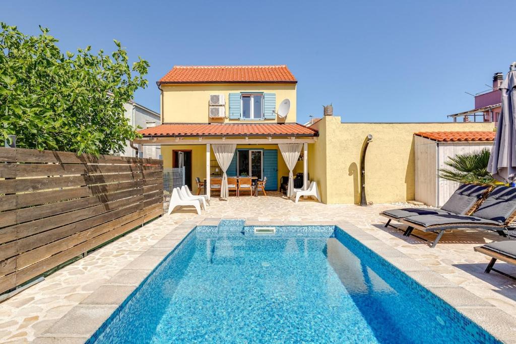 a swimming pool in front of a house at House Crassula in Murter