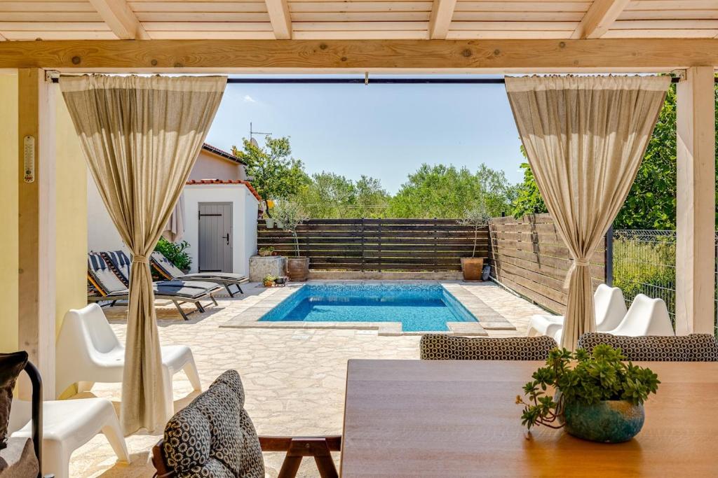 un patio con piscina, mesa y sillas en House Crassula, en Murter