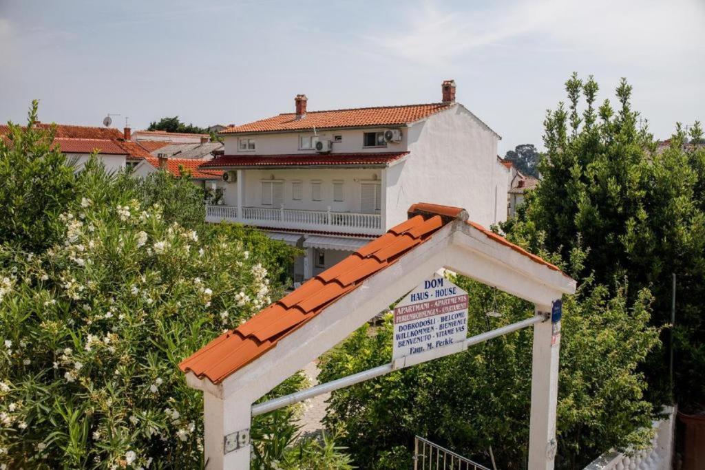 een wit huis met een bord ervoor bij Mile Ferienhaus in Rab