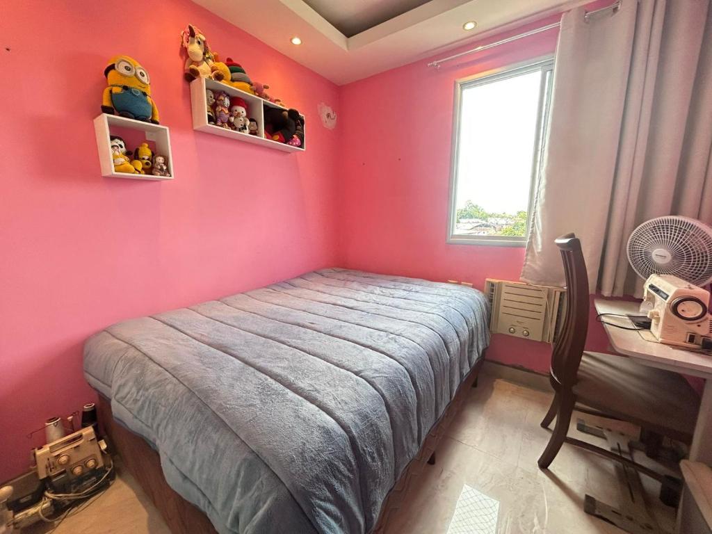 - une chambre rose avec un lit et un bureau dans l'établissement Apartamento simone 2 COP 30, à Água Boa