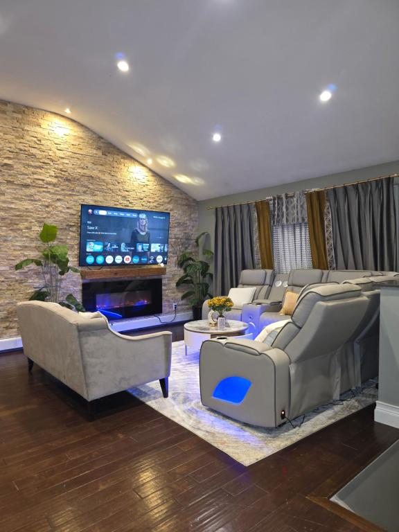 a living room with couches and a flat screen tv at BALDWIN HARBOR Aosis in Baldwin