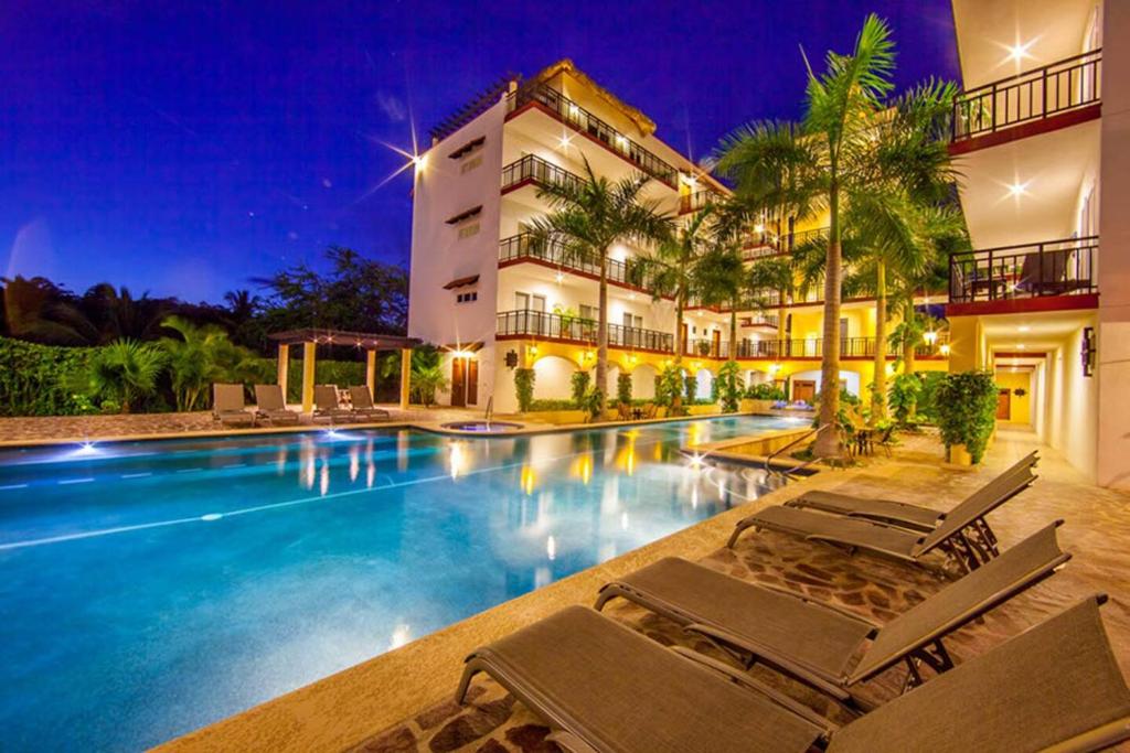 a hotel with a swimming pool with lounge chairs at Gorgeous Penthouse across from Beach with Ocean Views! in Punta Mita