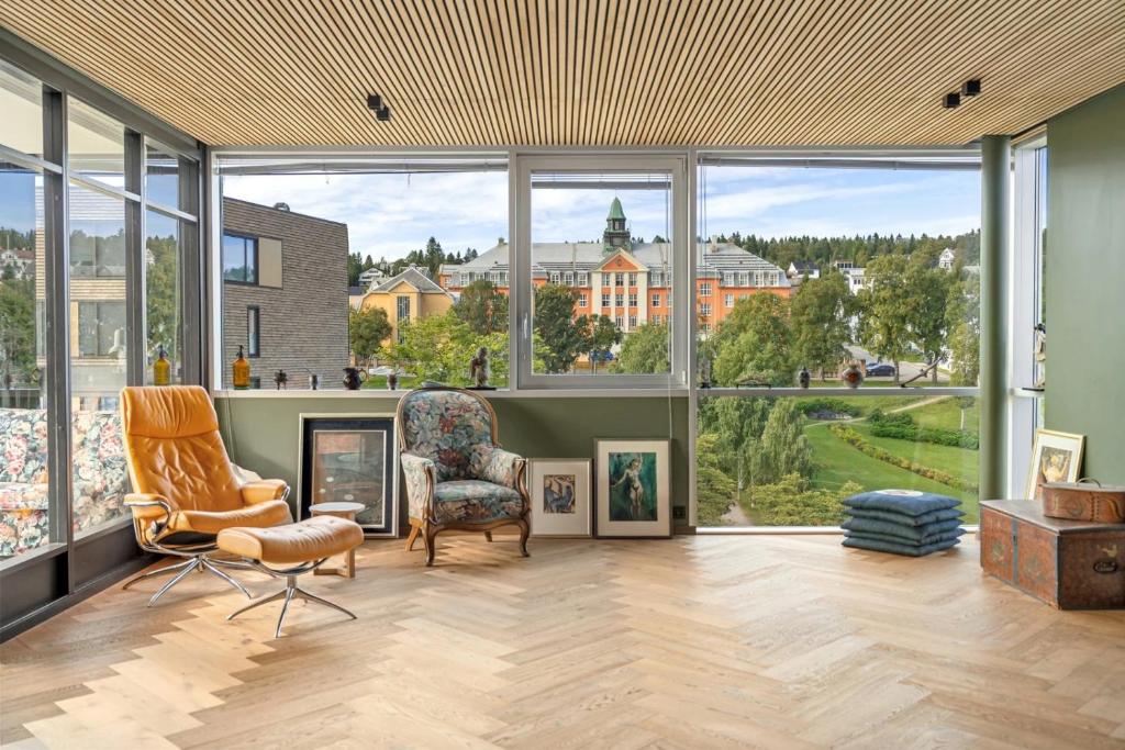 - un grand salon avec de grandes fenêtres et du mobilier dans l'établissement The Royal Penthouse by Paramount, à Tromsø