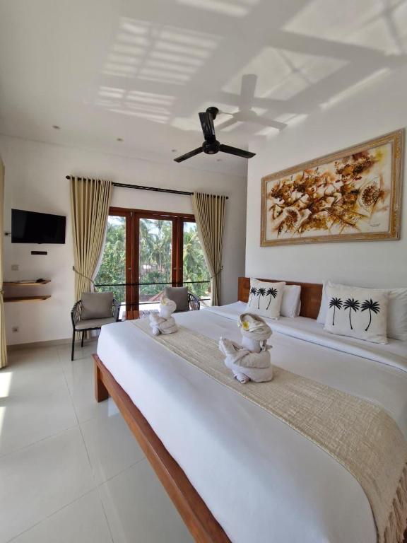 a bedroom with a large bed with two stuffed animals on it at Lemon Tree Hotel Bali in Lovina