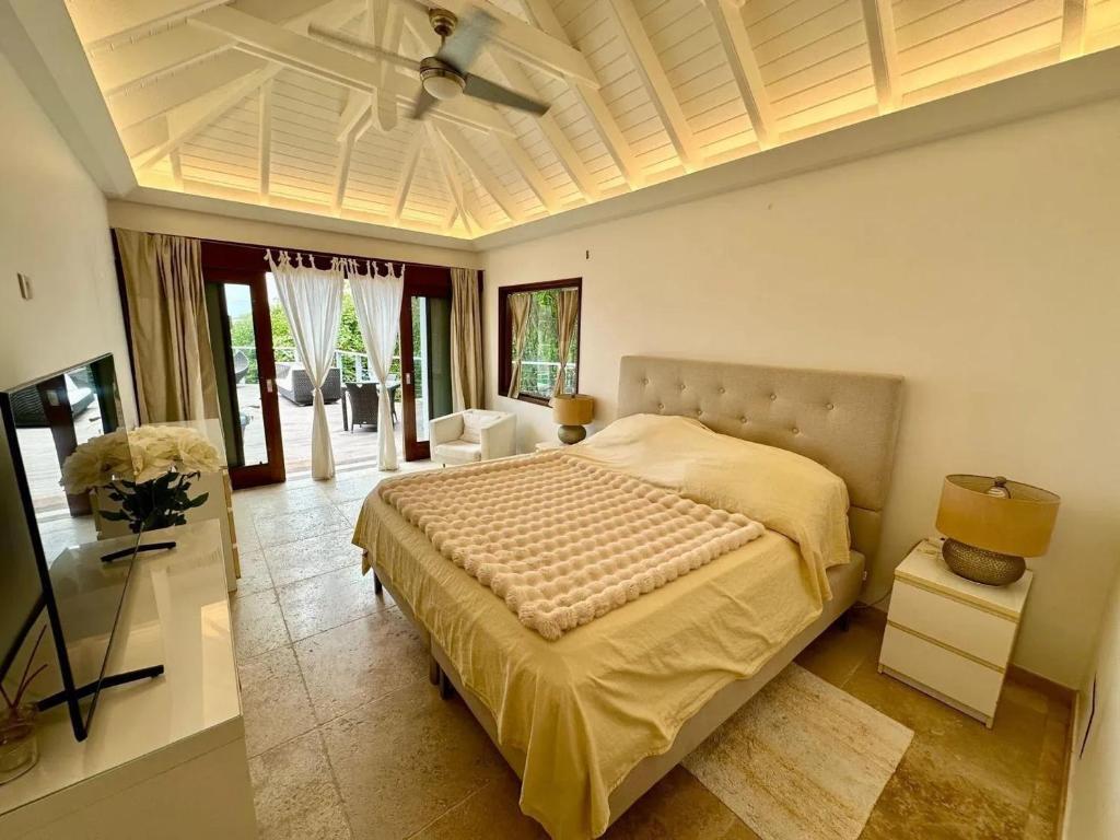 Un dormitorio con una cama grande y una sala de estar. en Modern Villa with Pool in Marigot - 100 m², en Marigot