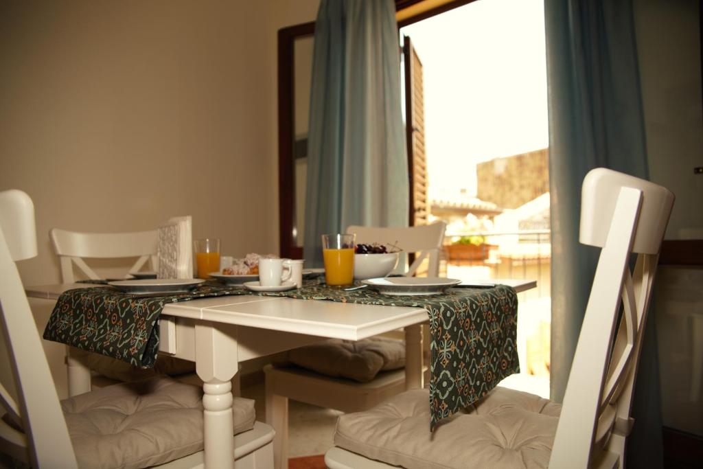 einem Esstisch mit Stühlen und einer Tischdecke darauf in der Unterkunft BnB DonnaLaura in Carini