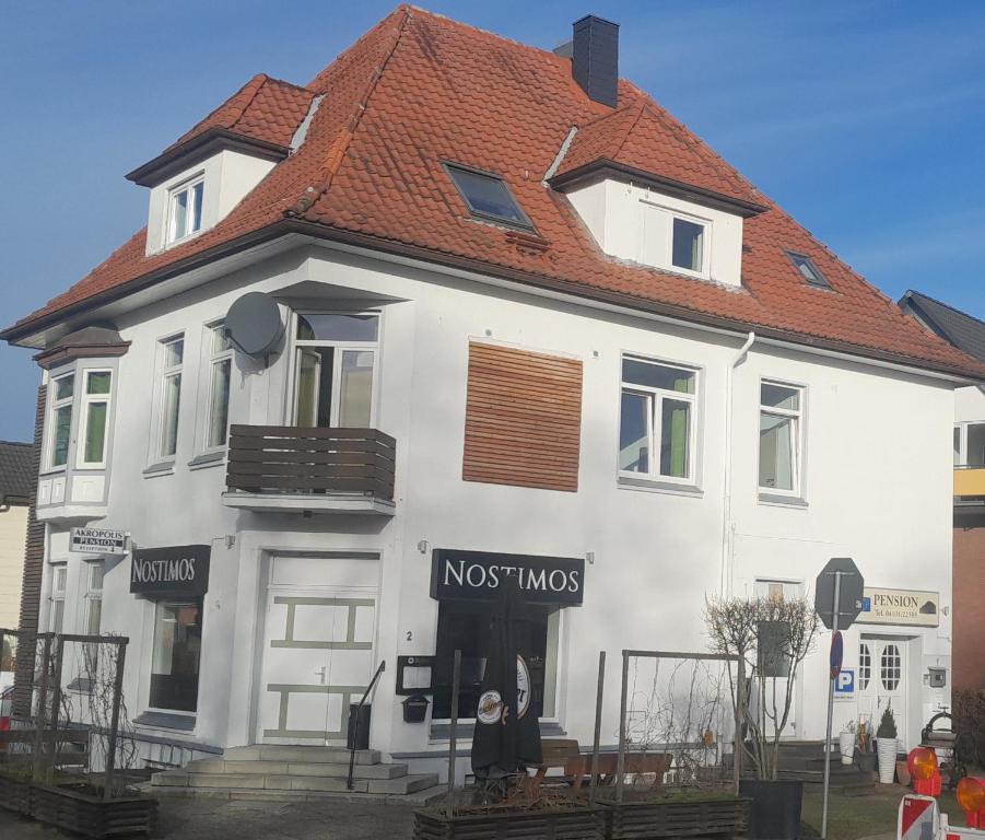 a large white house with a mustmos sign on it at Pensionen Akropolis in Rellingen
