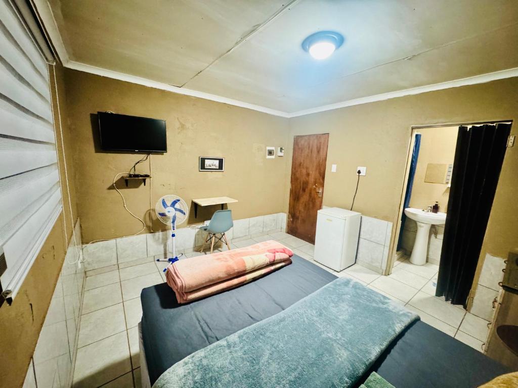 Habitación grande con cama y baño. en Tseleng Guest House, en Vosloorus