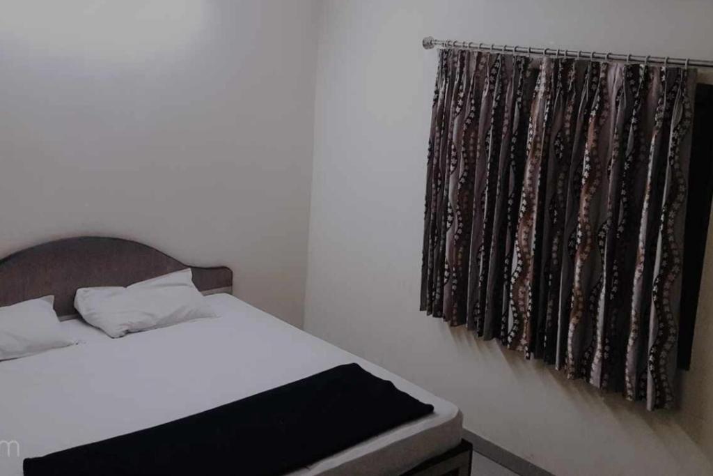 une chambre avec un lit et une fenêtre dans l'établissement Golden cottage, à Yercaud