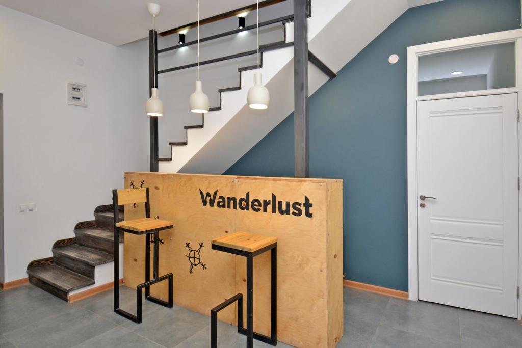 a room with a staircase and two stools with a sign that reads wantedtrust at Hostel Inn Northern Avenue in Yerevan