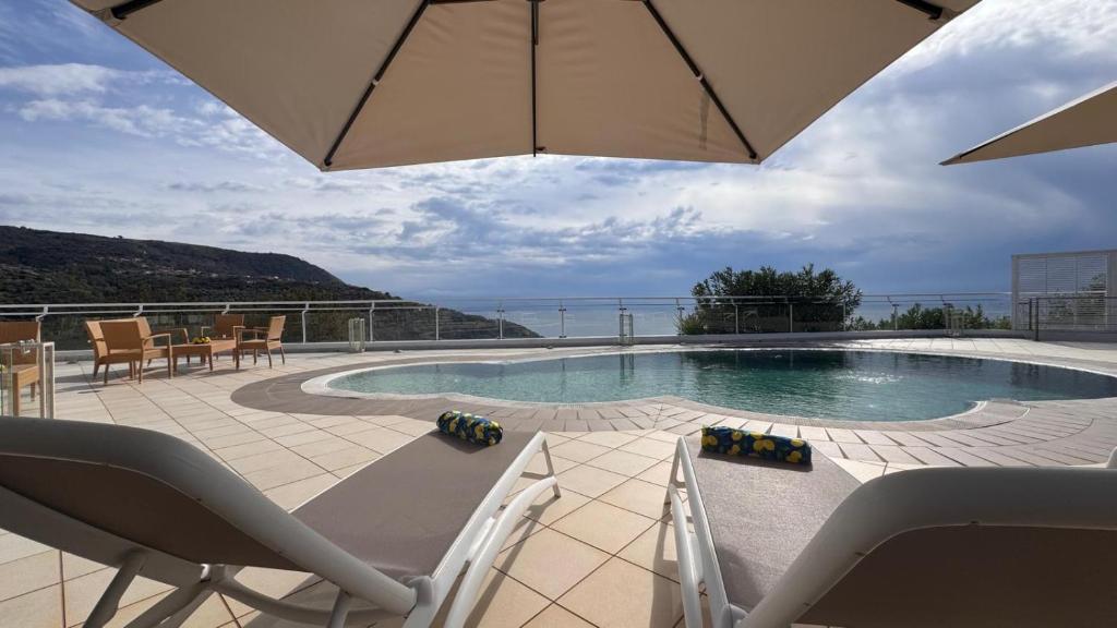 een zwembad met ligstoelen en een parasol bij Luxury Villa with Pool and Garden in Ricadi