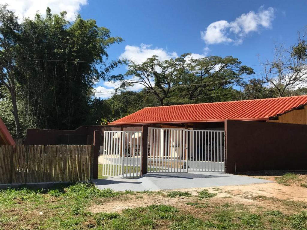 a gate to a house with a red roof at Chalés Dinhá- Pousada in Brumadinho
