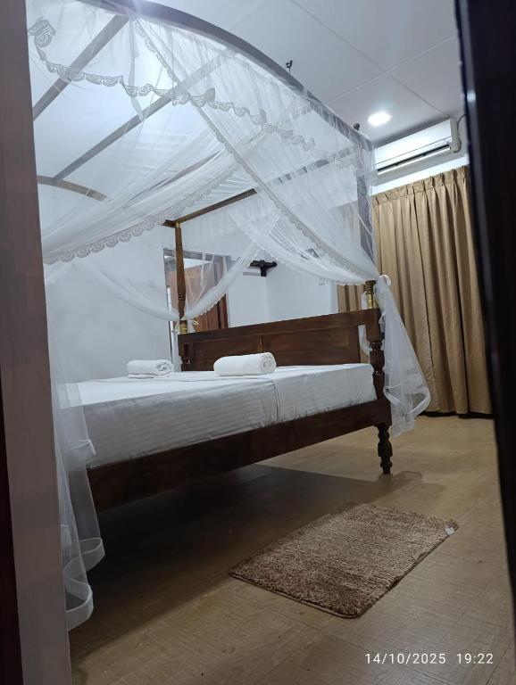 a bedroom with a bed with a canopy at Villa Senowin in Anuradhapura