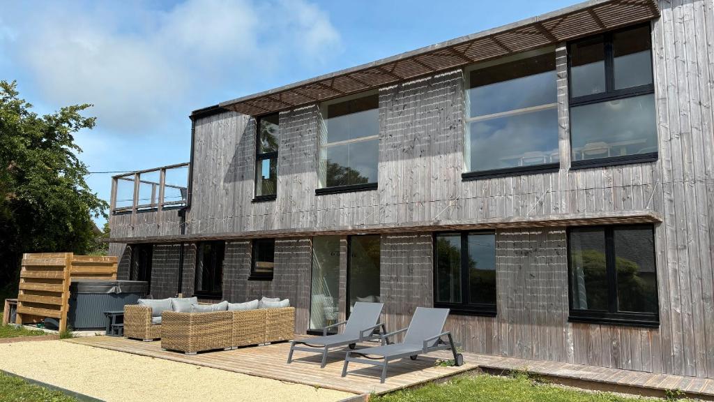 une maison avec deux chaises sur une terrasse dans l'établissement Villa Grande Est idéal famille Spa, à Plounéour-Trez