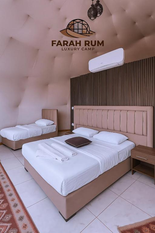 two beds in a room with a sign on the wall at FARAH RUM lUXURY CAMP in Wadi Rum