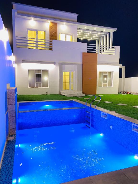a villa with a swimming pool in front of a house at شاليه ڤيو - View Chalet in Al Ḩadd