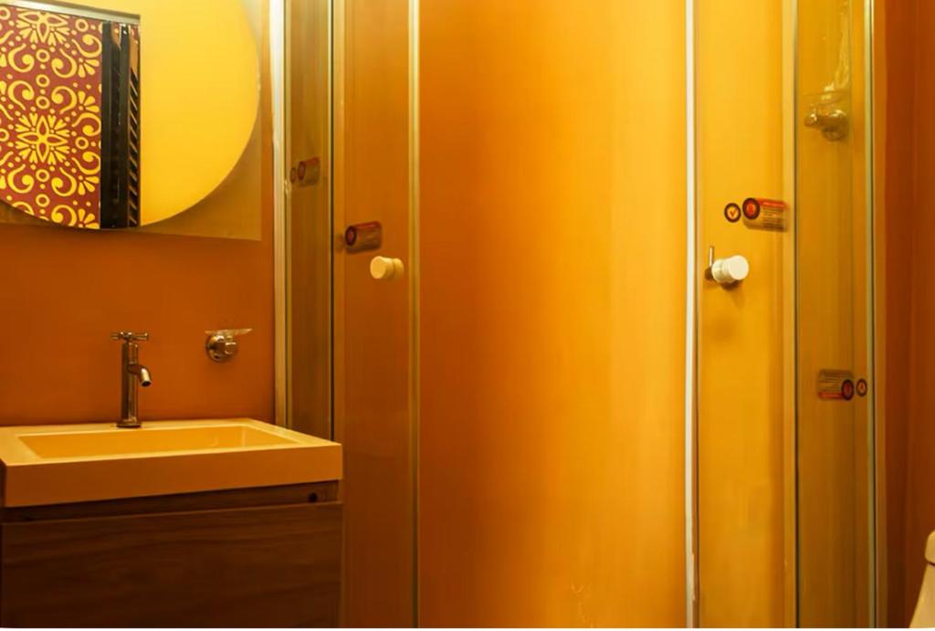 Un baño con lavabo y ducha con espejo. en Seven Nights Hostel Cartagena, en Cartagena de Indias