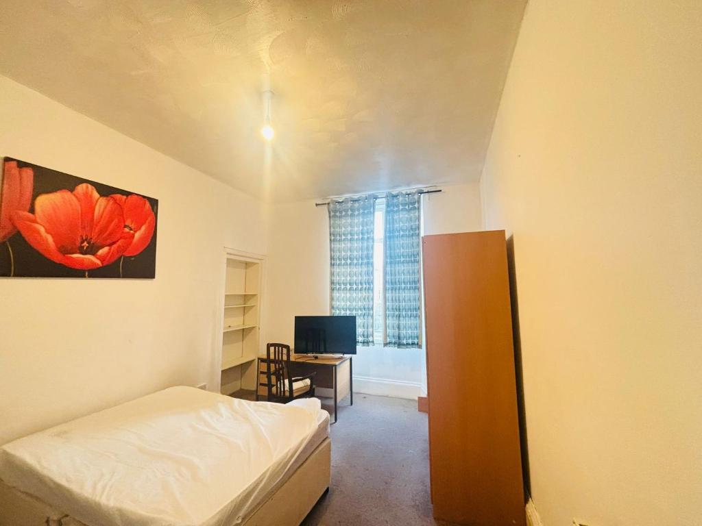 a bedroom with a bed and a desk and a window at Vintage Thistle House in Glasgow