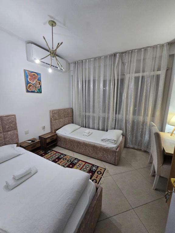 a hotel room with two beds and a window at Isabel Rooms in Tirana