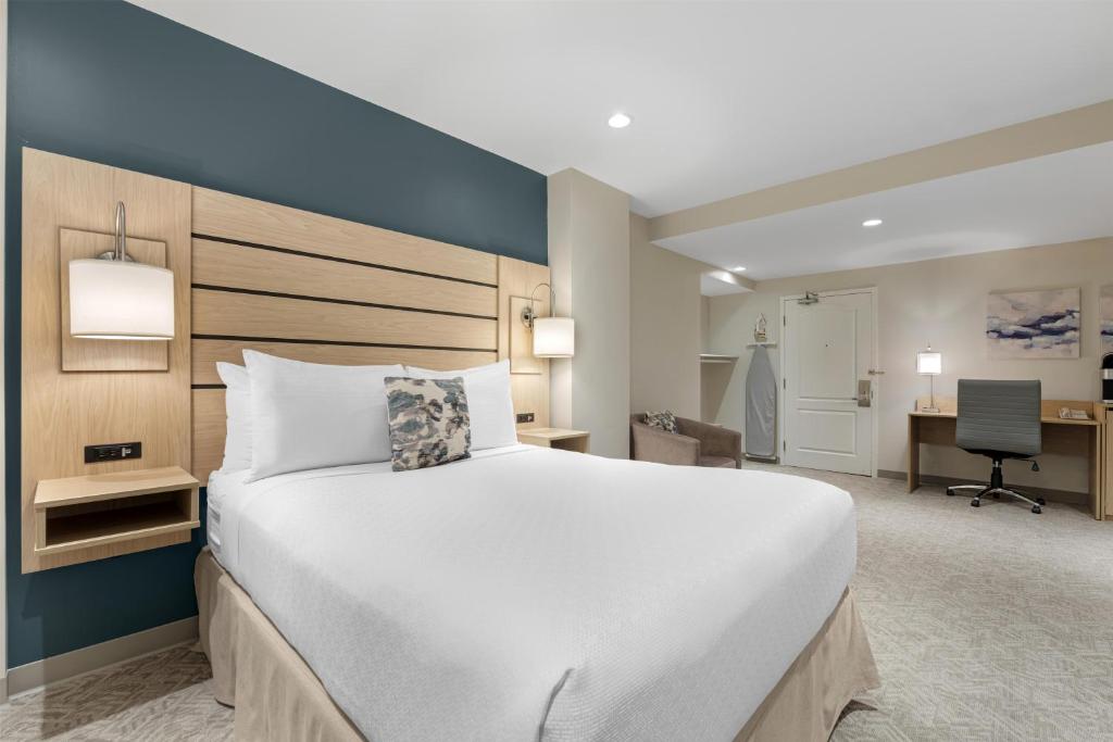 a bedroom with a large white bed and a desk at Best Western Plus Baker Street Inn in Nelson