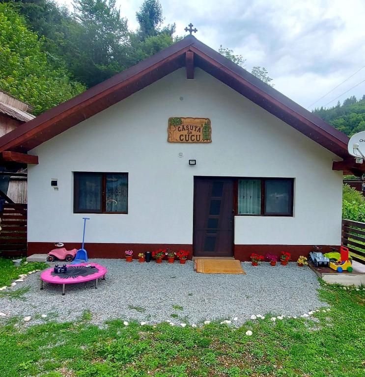 a white house with a sign on the front of it at Căşuţa LA CUCU in Vadu Moţilor