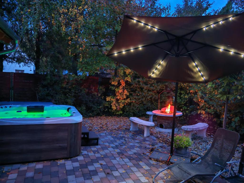 une terrasse avec un bain à remous et un parasol dans l'établissement TóPart Vendégház Velence, à Velence