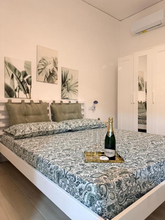 a bed with a bottle of champagne and glasses on it at Nido Flegreo in Pozzuoli