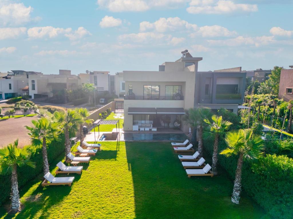 an aerial view of a house with lounge chairs and palm trees at Luxury Villa with Heated Pool & Private cinema in Marrakesh