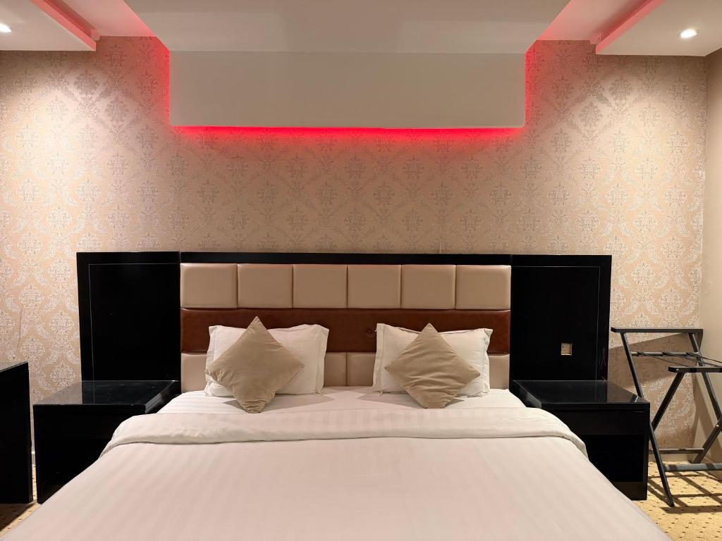 a bedroom with a large bed with a red light above it at فندق اكارم اشبيليا - Akarem ishbilia Hotel in Riyadh
