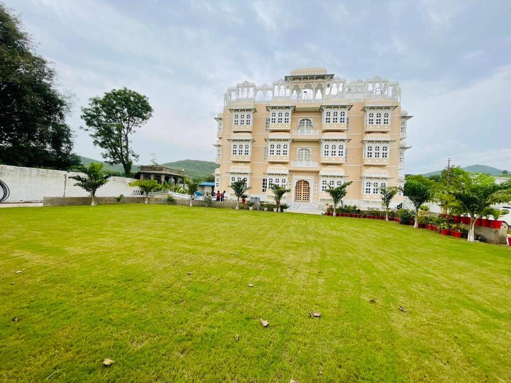 a large building with a grassy field in front of it at Aryavarta A Boutique Abode in Nāi