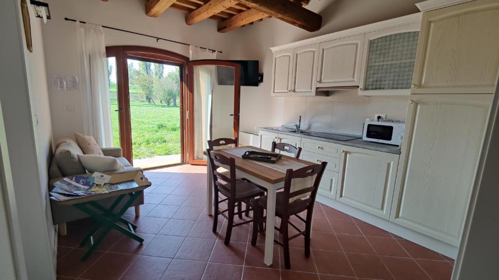 cocina con mesa y sillas y comedor en Agriturismo Villa Luisa, 