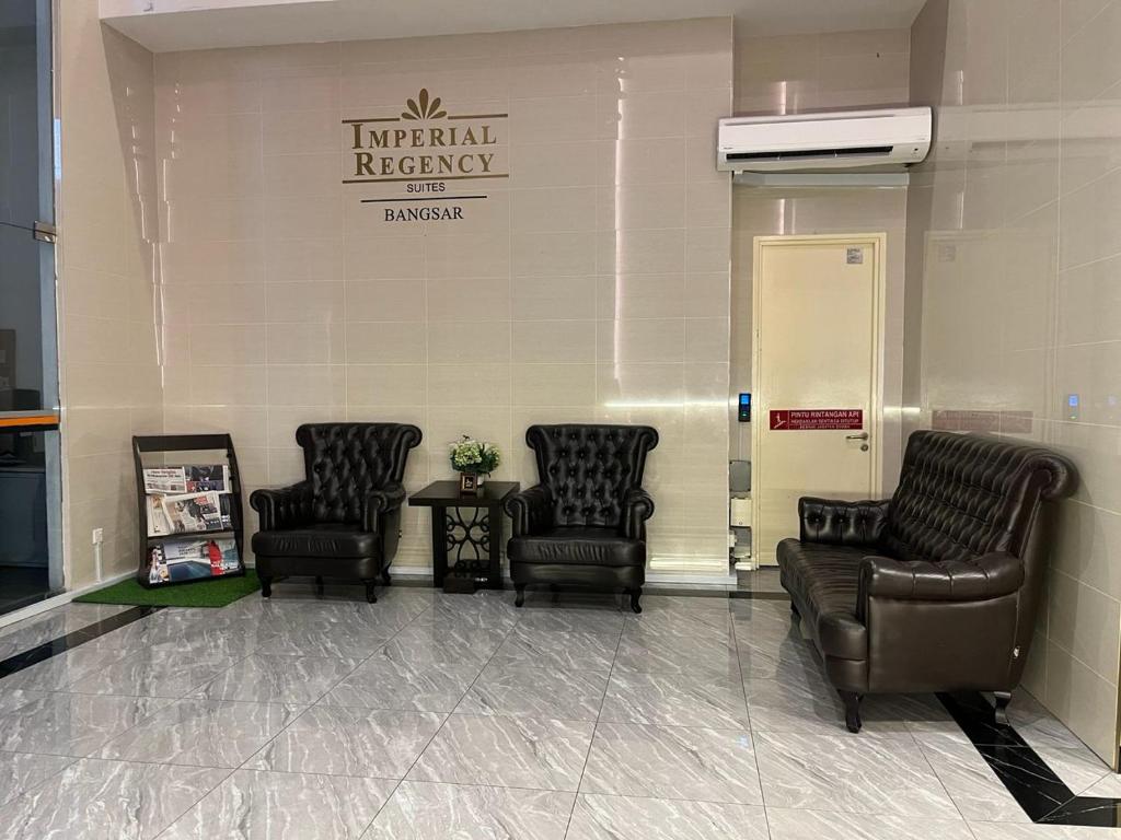 A small waiting area with leather armchairs beside the Imperial Regency Suites sign.