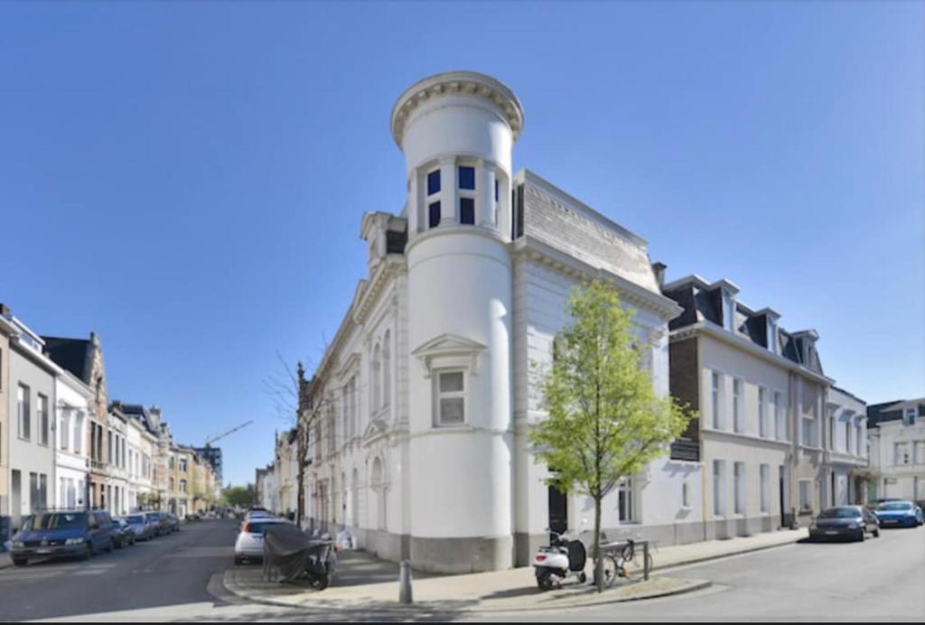a building with a tower on the side of a street at Architectonisch en kunsthistorisch droomverblijf in Antwerpen in Antwerp