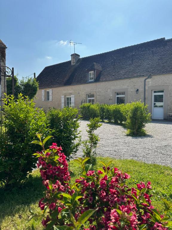 a garden with pink flowers in front of a building at La Maison de Charme, grand jardin, proche Argentan, idéale Amis et Familles in Sévigny
