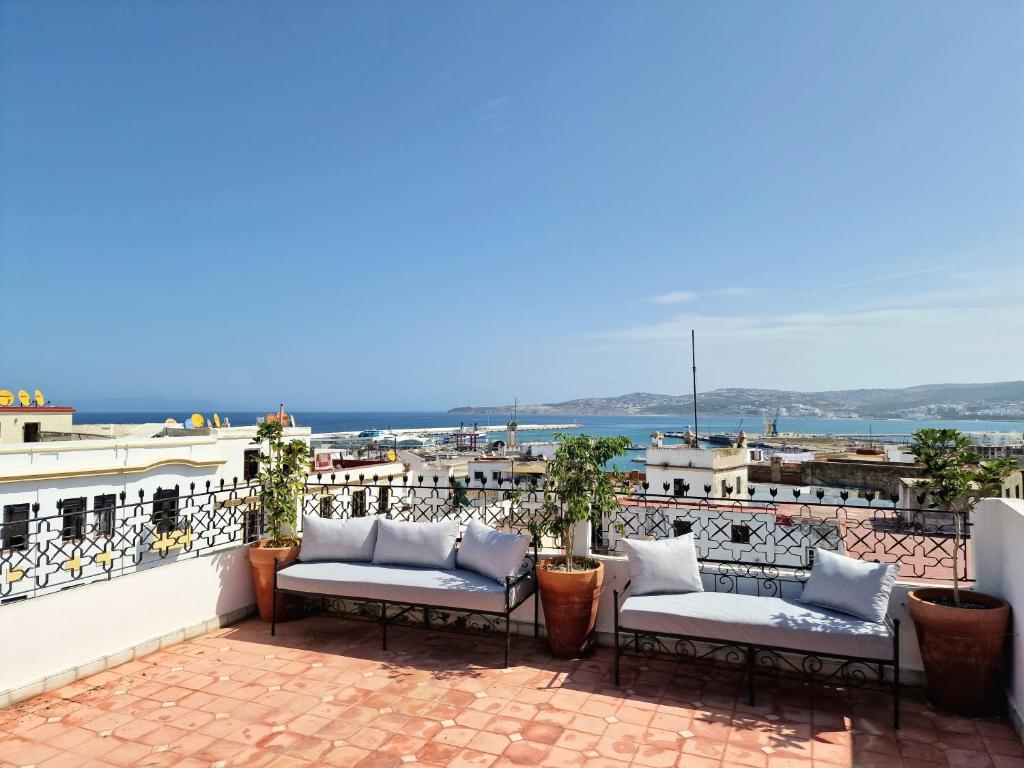 a balcony with chairs and a view of the ocean at AMY Brothers Apartments in Tangier