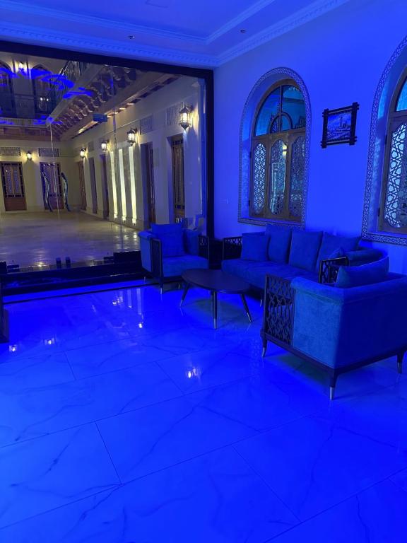 a living room with blue lighting and couches and a pool at Khalid Boutique in Bukhara