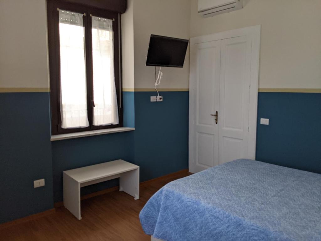 ヴィッラ・サン・ジョヴァンニにあるMola Mola Beach Houseのベッドルーム(ベッド1台、窓、テレビ付)