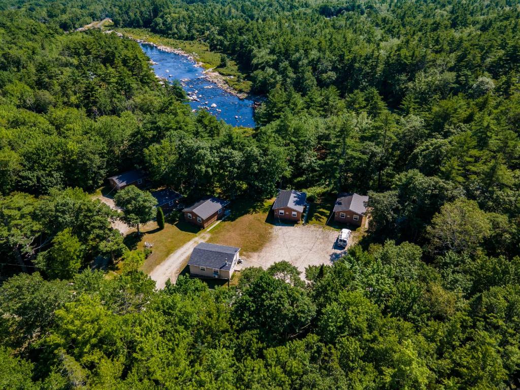 une vue aérienne d'un groupe de terrains de camping à côté d'une rivière dans l'établissement Roseway River Cottages, à Shelburne