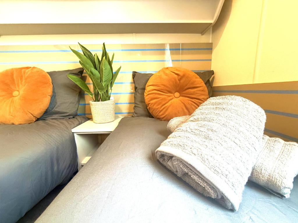 a bedroom with two beds and two orange pillows at Grand Horizon in Hunmanby