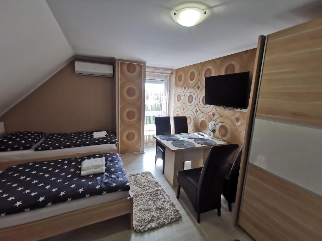 a small room with a bed and a table with chairs at Fáraó vendégház in Zalaegerszeg