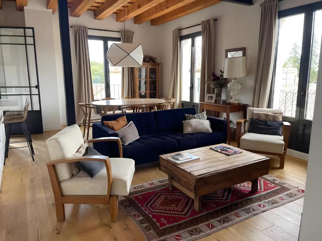 ein Wohnzimmer mit einem blauen Sofa und einem Tisch in der Unterkunft Rio Tío Cocinas in La Granja de San Ildefonso